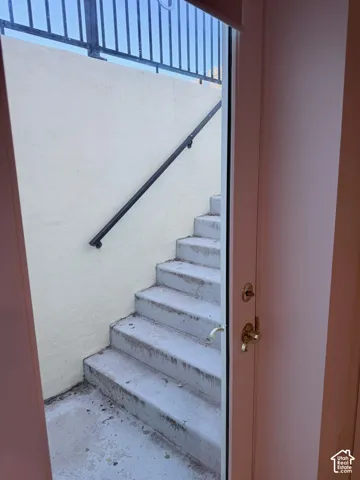 Exterior concrete stairs with a black metal handrail