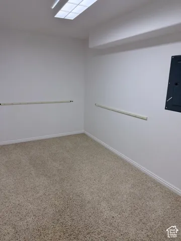 Recessed ceiling lighting, white painted walls, and textured carpeting
