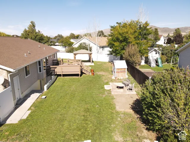 Expansive backyard featuring a multi-level wood deck, a covered gazebo, and a storage shed