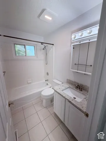 White tile flooring with a matching subway tile shower surround and bathtub