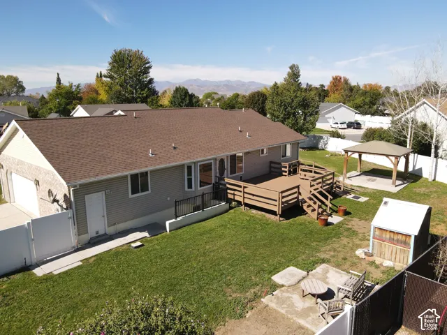 Expansive backyard featuring a multi-level wood-finish deck, a detached gazebo with a metal roof, and a privacy fence