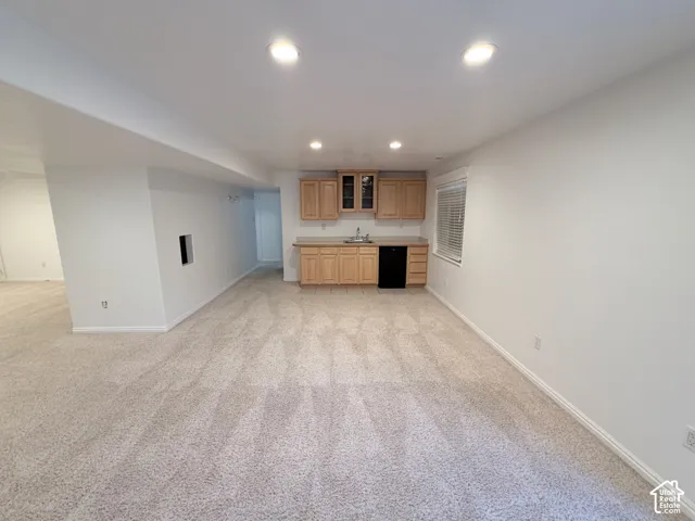 Recessed lighting, light-toned carpet flooring, built-in cabinetry with a sink, window with blinds, and white painted walls