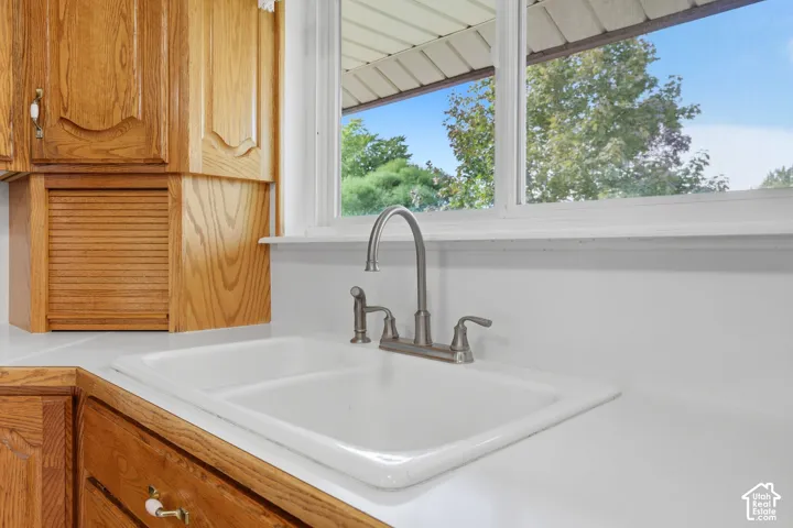 White countertop with an integrated single-basin sink and a brushed nickel gooseneck faucet