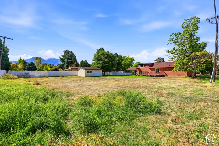 Expansive lot featuring a separate outbuilding, a brick exterior residence, and a wood deck