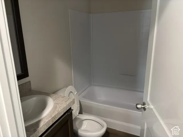 White wall-mounted tub and shower combination with a textured surround