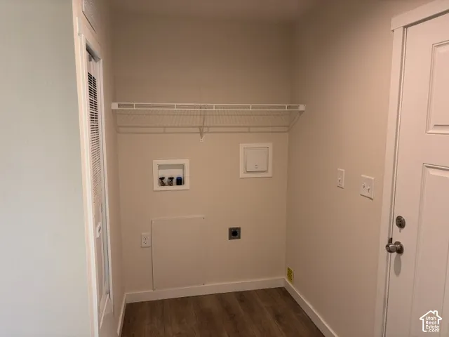 Dedicated laundry area featuring a white wire shelf, wood-finish flooring, and a louvered door