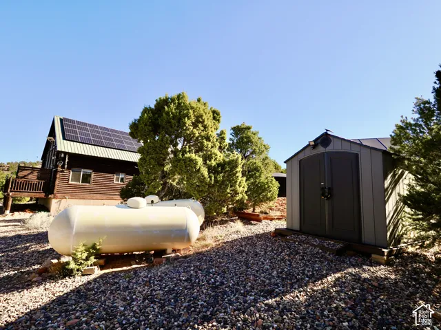 Wood-sided residence with solar panels and an exterior deck