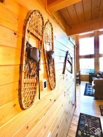 Wood-paneled wall, wood-finish flooring, exposed wood beam ceiling, and expansive windows