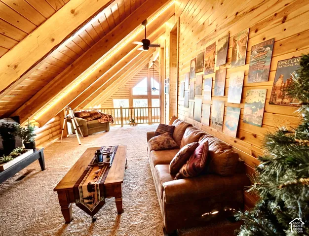 Vaulted wood-paneled ceilings, natural wood wall finishes, wood flooring, and a ceiling fan
