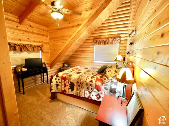 Wood paneling throughout, vaulted wood-plank ceiling, and a ceiling fan with integrated lighting