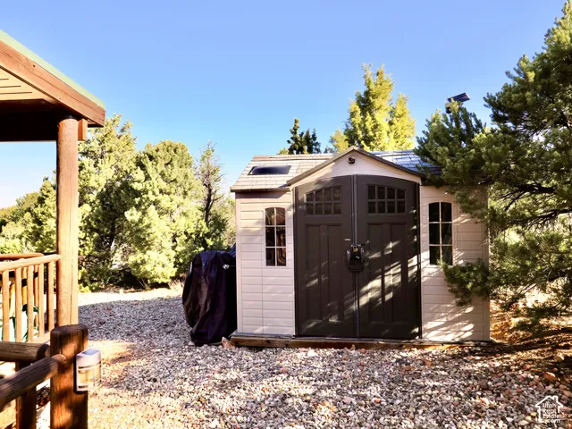 Utility shed with arched double doors, side windows, and a skylight