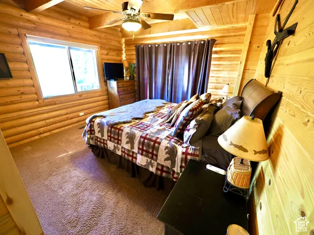 Wood-paneled walls and ceiling featuring exposed beams