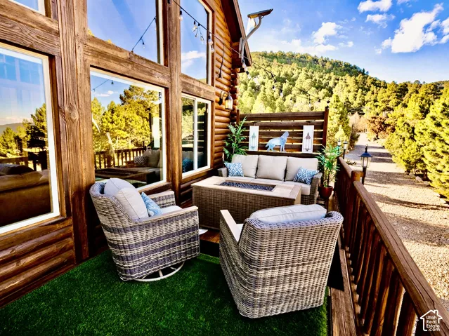 Expansive deck with wood railing, large window panels, and artificial turf flooring