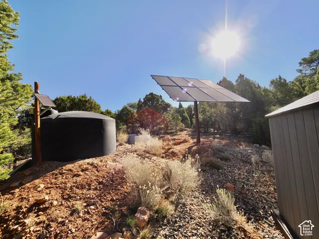 Solar panel array with a dark water storage tank and a utility shed