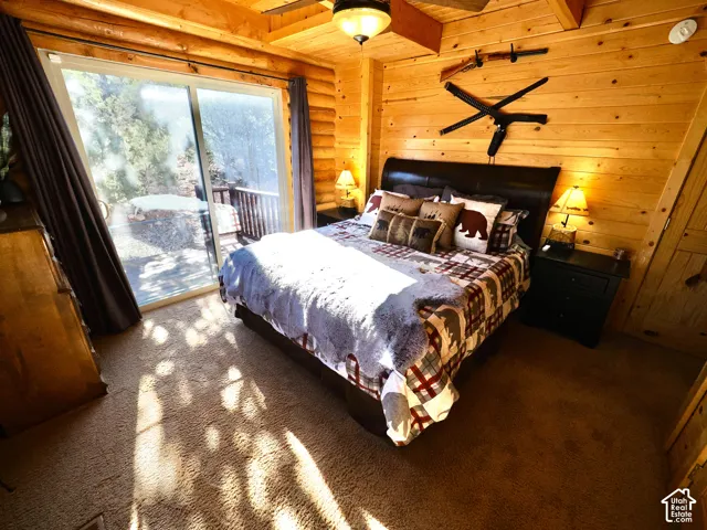 Wood-paneled room featuring a sliding glass door, a built-in deck, and a ceiling fan with integrated lighting
