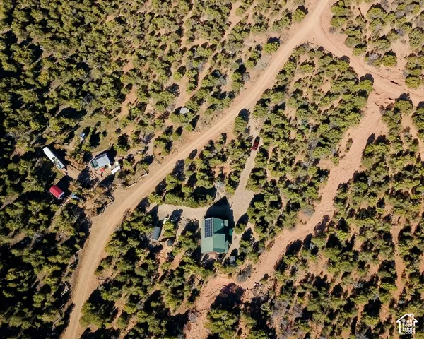Expansive property featuring a central residence with solar panels, multiple outbuildings, and extensive natural landscaping