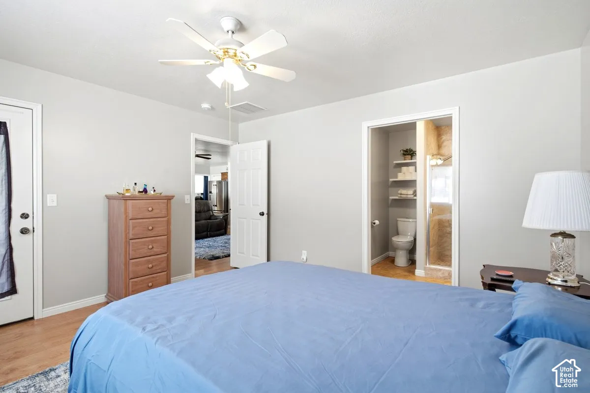 Bedroom featuring wood-finish flooring, a ceiling fan, and a light gray wall color