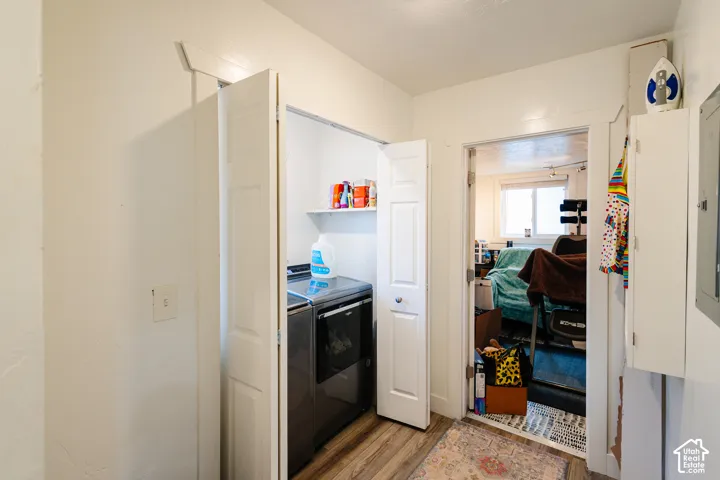 Laundry area with wood-finish flooring, bi-fold doors, and a built-in shelf