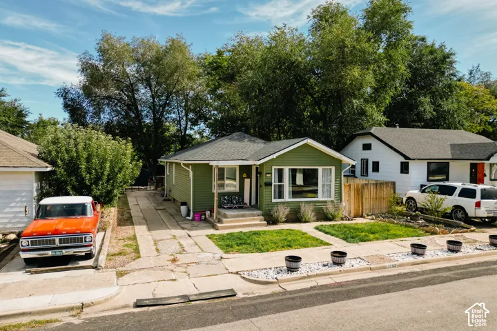 Green siding exterior with a dark shingle roof