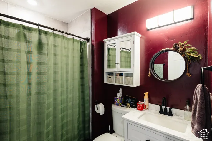 Bathroom featuring a vanity with a white countertop and integrated sink, a wall-mounted medicine cabinet, and overhead lighting