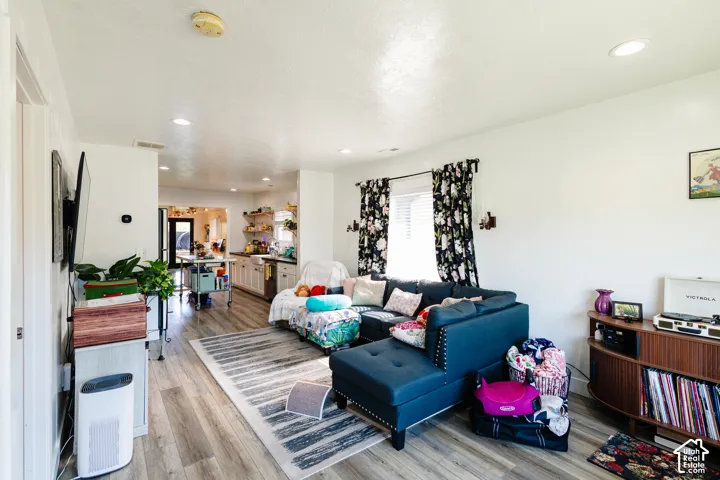 Recessed lighting, wood-finish flooring, and white walls