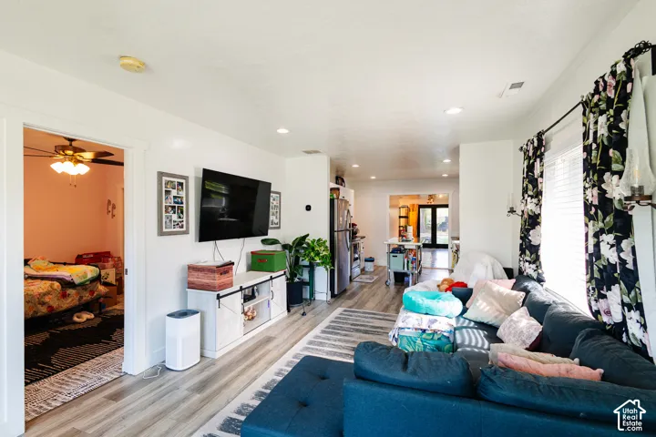 Recessed lighting, wood-finish flooring, white walls, and a ceiling fan