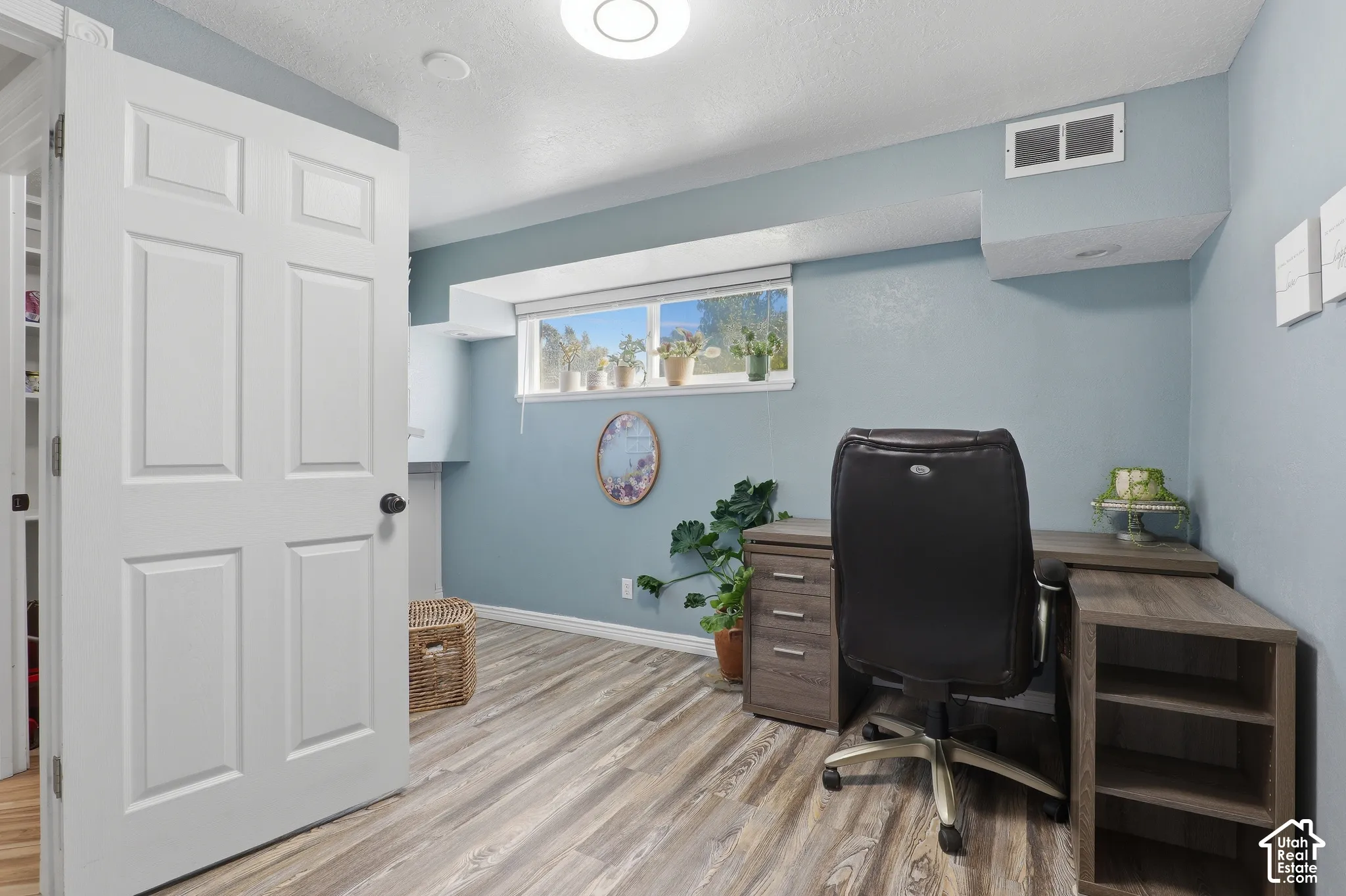 Wood-finish flooring, recessed ceiling light, and a window providing natural illumination