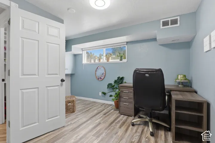 Wood-finish flooring, recessed ceiling light, and a window providing natural illumination