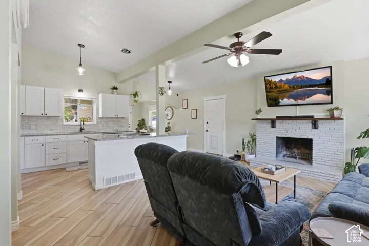 White shaker cabinetry with dark hardware, a mosaic tile backsplash, and light-toned countertops