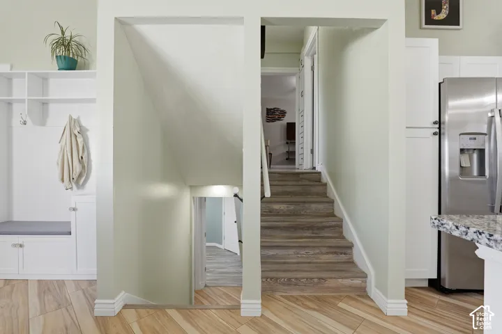 Built-in storage bench with shelving, wood-finish flooring, and white cabinetry