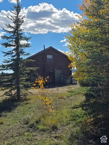 Wood-sided exterior with a gabled roofline and exposed chimney
