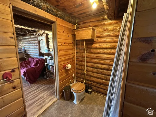 Log wall construction with exposed ceiling beams and wood-finish flooring