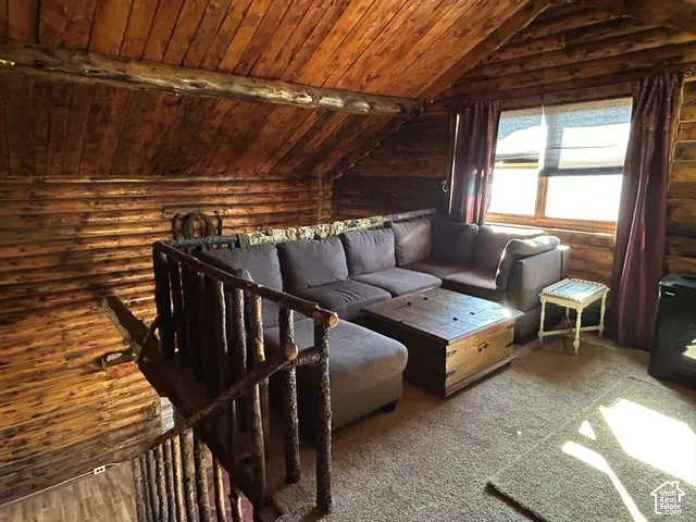 Log wall and ceiling finishes, natural wood stair railing, and dual windows
