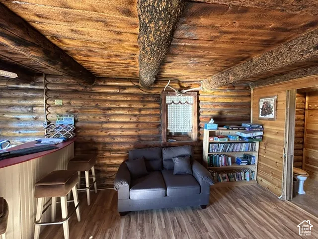 Log wall construction, exposed log beams, wood-finish flooring, built-in bar, wood paneling