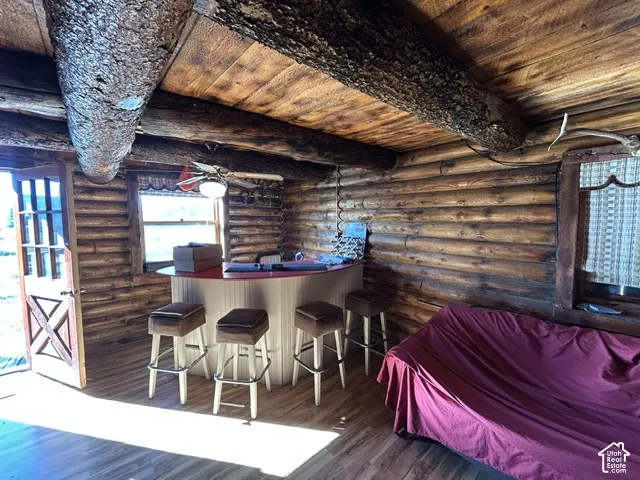 Log construction interior with exposed log beams and wood-finish flooring
