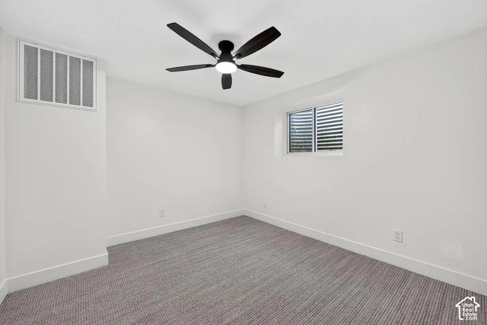 Recessed window, ceiling fan with integrated lighting, and neutral carpeting