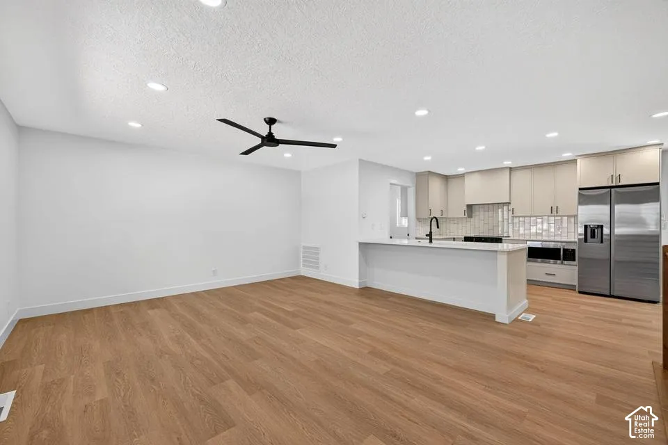 Wood-finish flooring throughout, recessed lighting, and a modern black ceiling fan