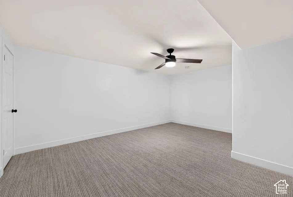 Carpeted flooring, white walls, and a ceiling fan with integrated lighting