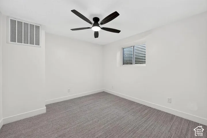 Recessed window, ceiling fan with integrated lighting, and neutral carpeting