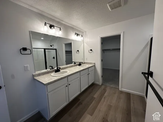 Dual vanity with white cabinetry, light-colored countertops, and matte black fixtures