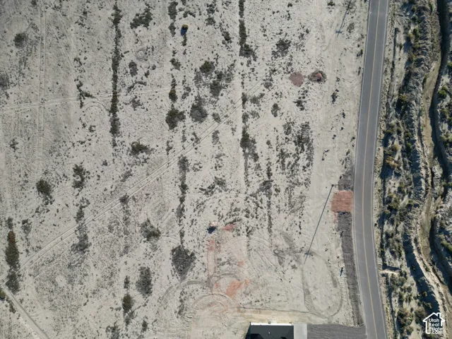Expansive undeveloped land featuring a paved road, natural desert terrain, and visible ground markings