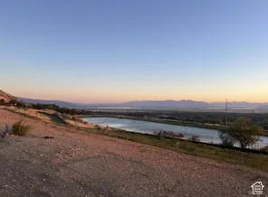 Expansive sky with a distant mountain range, large body of water, and surrounding terrain