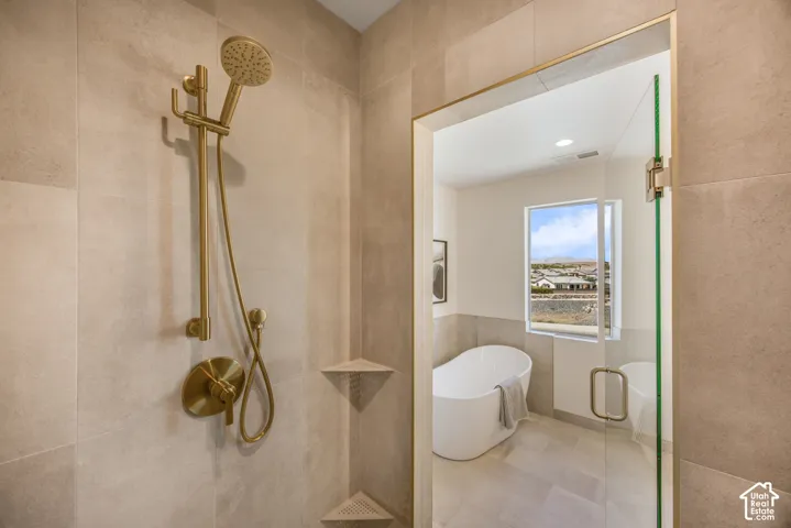 Enclosed shower with a handheld showerhead and gold-tone fixtures