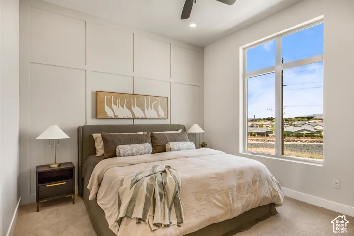 Tall window providing ample natural light, panel accent wall, recessed lighting, and a ceiling fan