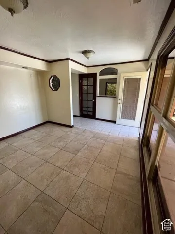 Expansive tile flooring, arched entryways, dark-stained trim throughout, and recessed lighting fixtures