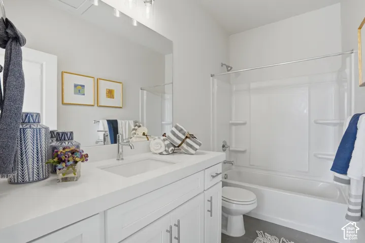 White vanity with an integrated sink, polished chrome faucet, and bright overhead lighting