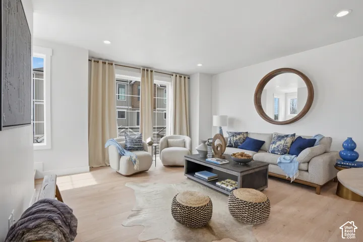 Recessed ceiling lighting, light wood-finish flooring, multiple windows, and a built-in coffee table