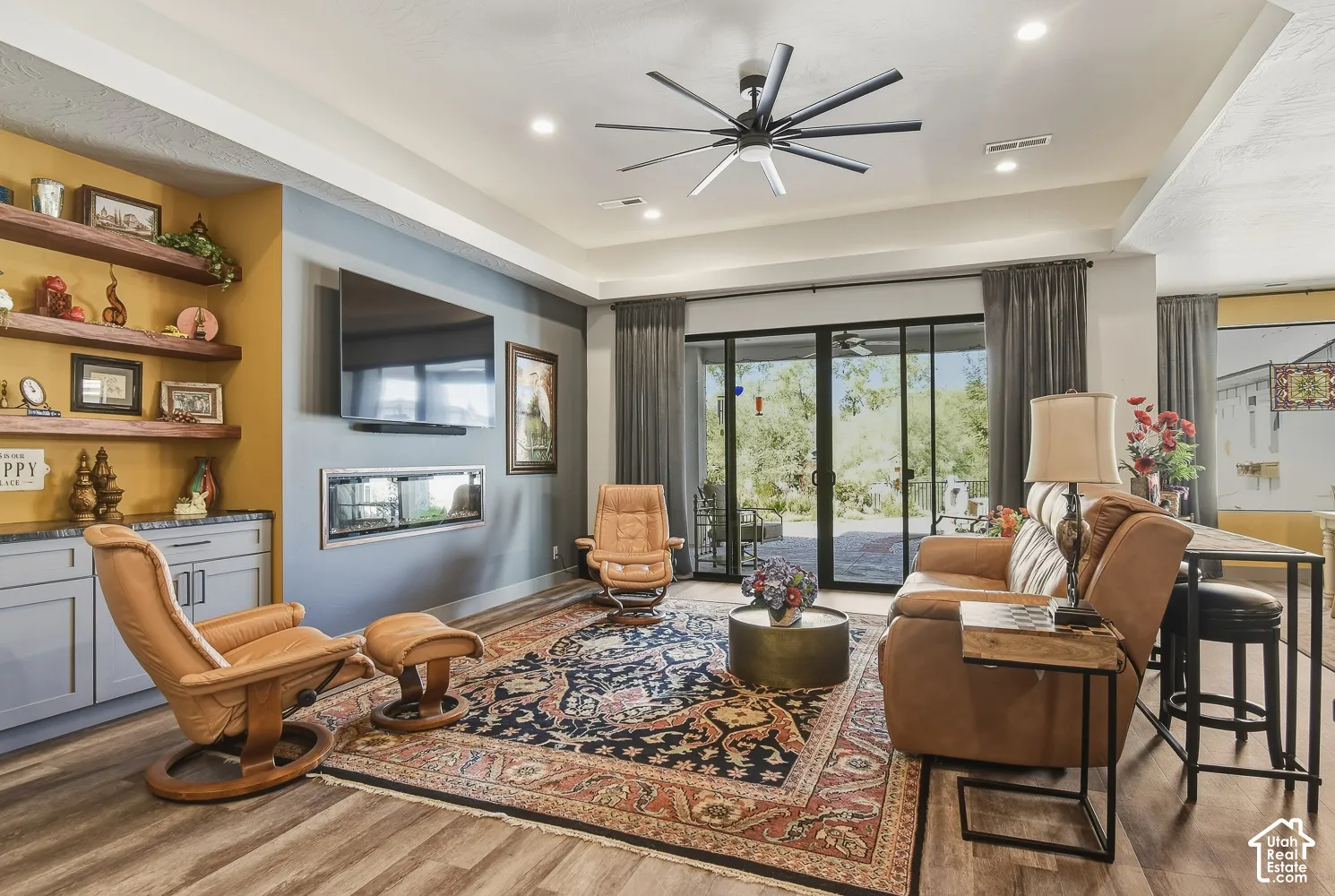 Spacious living room with built in shelving and sliding glass doors to the backyard