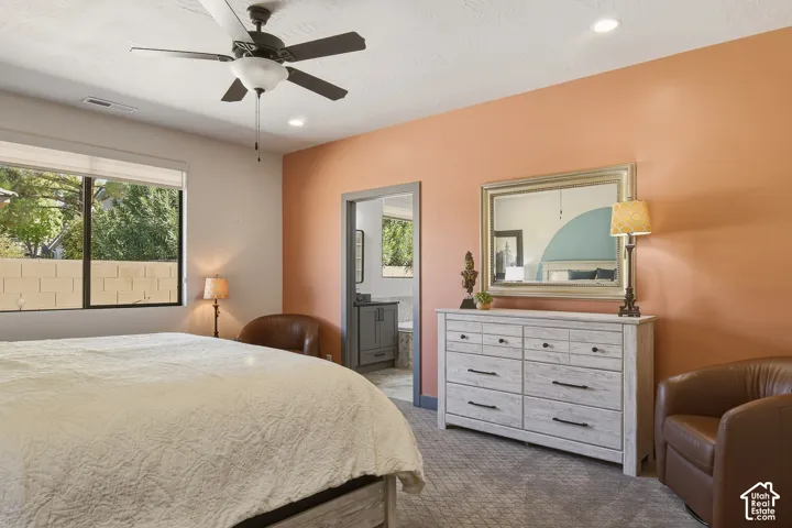 Large primary bedroom with accent walls and ceiling fan