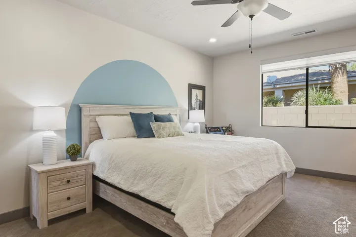 Large primary bedroom with accent walls and ceiling fan